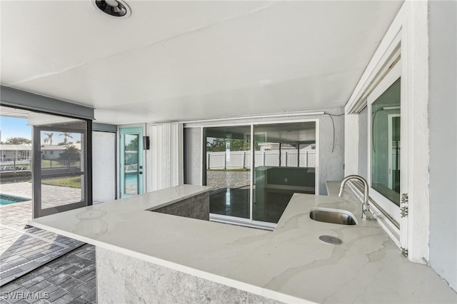 kitchen with light stone counters and a sink