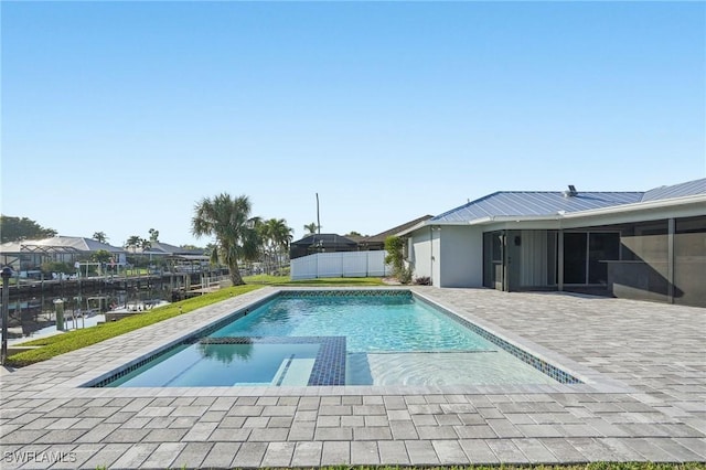 view of swimming pool with a sunroom, a patio, fence, and a pool with connected hot tub