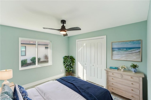 bedroom with a closet, ceiling fan, and baseboards