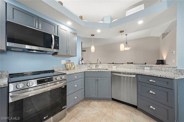 kitchen with stainless steel appliances, sink, pendant lighting, and kitchen peninsula