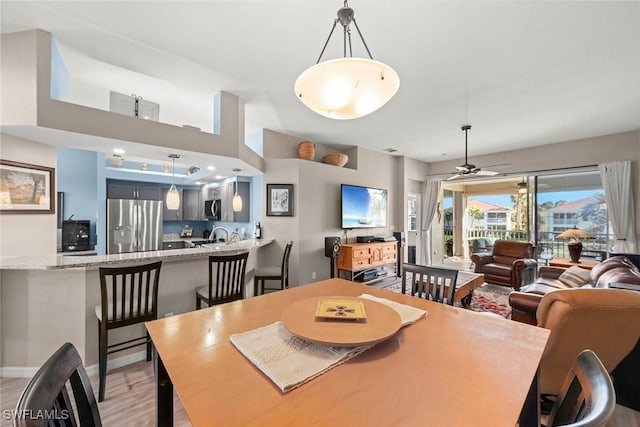 dining room with ceiling fan and light hardwood / wood-style floors