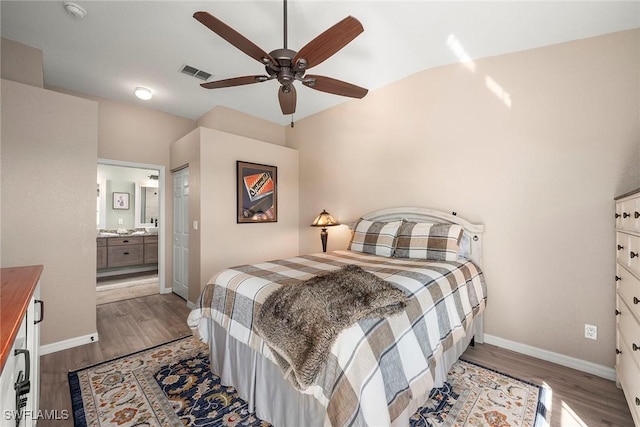 bedroom with connected bathroom, dark hardwood / wood-style floors, and ceiling fan