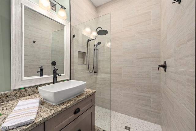 bathroom with vanity and a tile shower