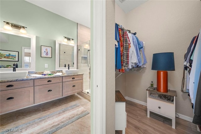 bathroom with vanity, wood-type flooring, and a tile shower