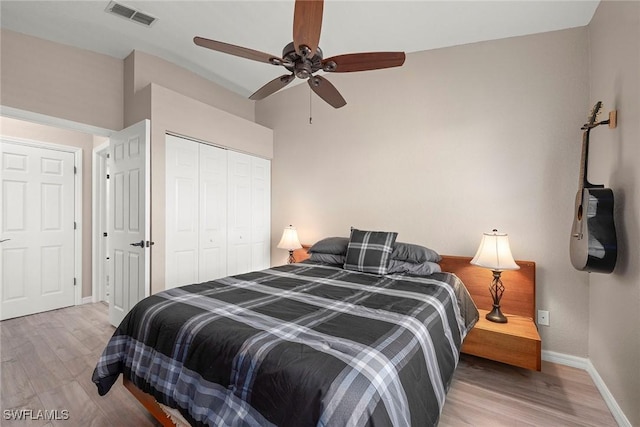 bedroom with hardwood / wood-style floors, ceiling fan, and a closet