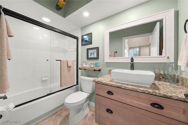 full bathroom featuring bath / shower combo with glass door, vanity, tile patterned floors, and toilet