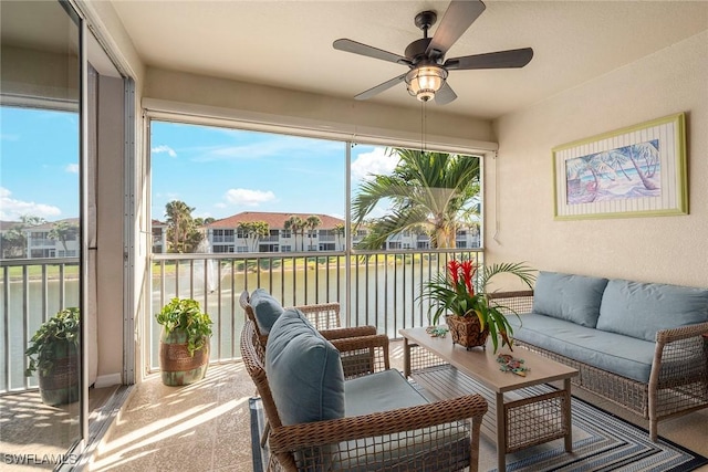 sunroom with a water view and ceiling fan