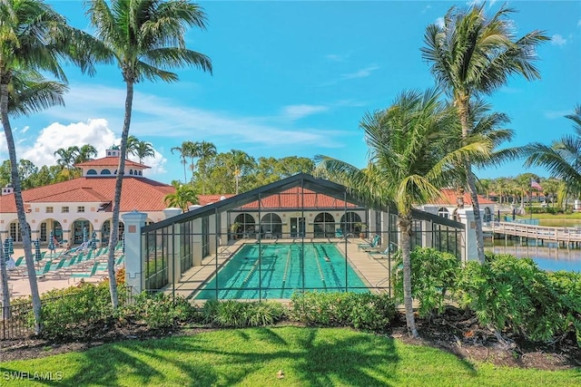 view of pool with a water view and a lawn