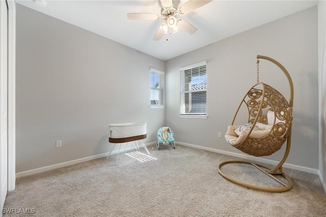 sitting room with ceiling fan and carpet