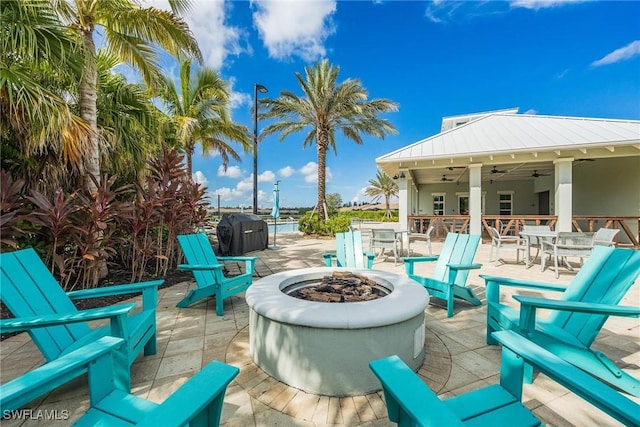 view of patio with grilling area, ceiling fan, and a fire pit