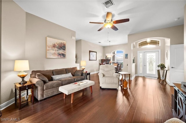 living room featuring dark wood-type flooring and ceiling fan