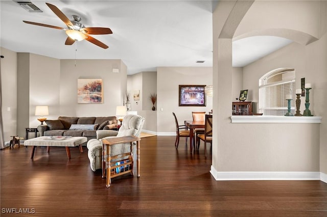 living room featuring dark wood-type flooring and ceiling fan