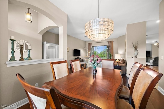 dining area with wood-type flooring and an inviting chandelier