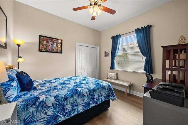 bedroom with hardwood / wood-style flooring, ceiling fan, and a closet