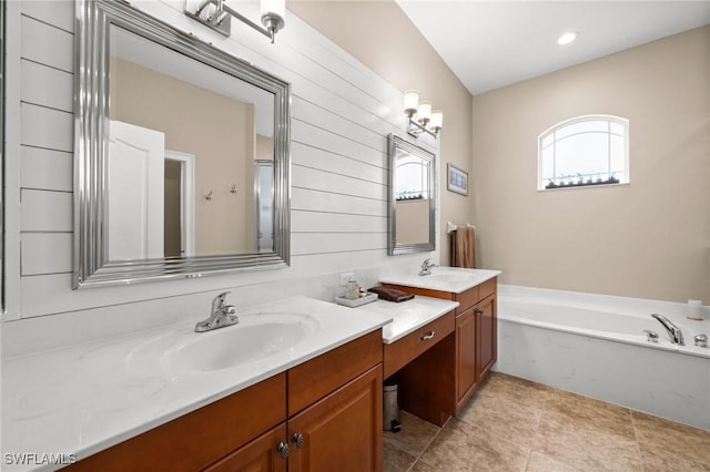 bathroom with tile patterned floors, a tub to relax in, and vanity