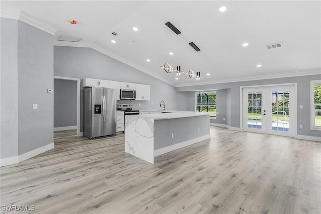 kitchen with white cabinetry, ornamental molding, light stone counters, stainless steel appliances, and french doors