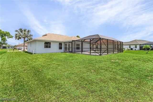 back of property featuring a yard and glass enclosure