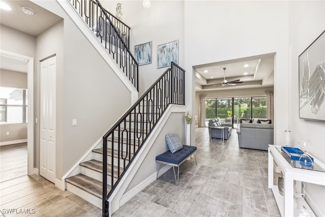 4641 Azalea Dr, Naples, FL 34119 - staircase featuring a tray ceiling, recessed lighting, baseboards, a towering ceiling, and ceiling fan