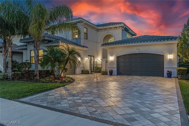 4641 Azalea Dr, Naples, FL 34119 - mediterranean / spanish home featuring a gate, a tiled roof, decorative driveway, a garage, and stucco siding