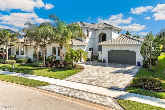 4641 Azalea Dr, Naples, FL 34119 - mediterranean / spanish-style house featuring a front yard, stucco siding, a tiled roof, decorative driveway, and a garage