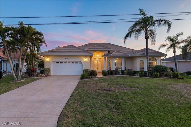 view of front of property featuring a yard and a garage