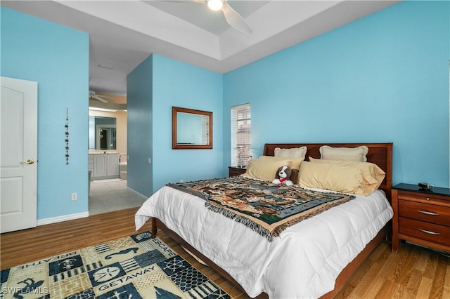 bedroom with light hardwood / wood-style floors, ceiling fan, and ensuite bathroom