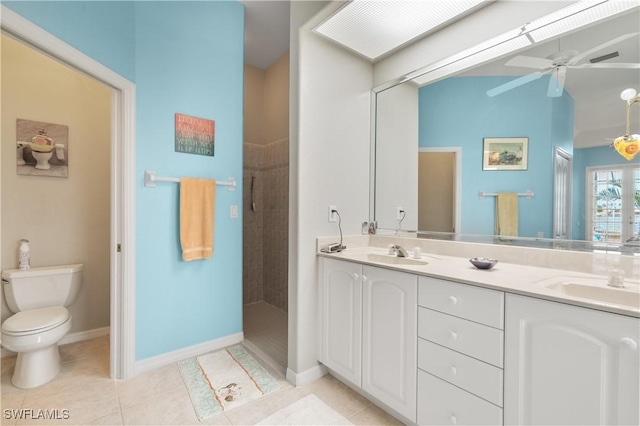 bathroom with tile patterned flooring, vanity, tiled shower, ceiling fan, and toilet