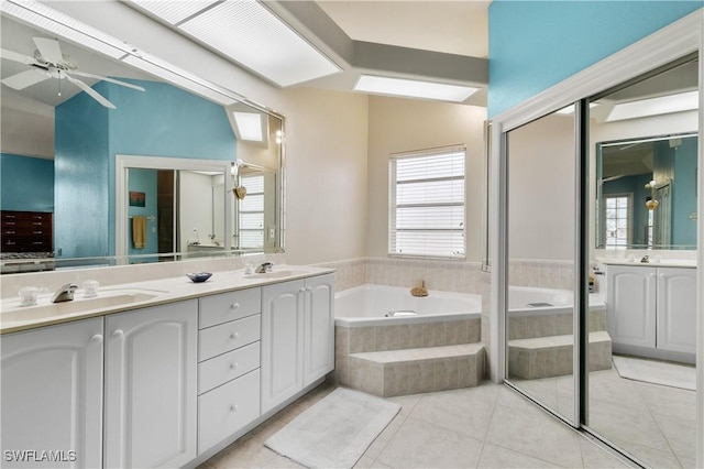 bathroom featuring tiled tub, vanity, tile patterned floors, and ceiling fan