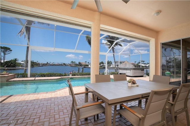 view of pool featuring a water view, a hot tub, a patio, and a lanai