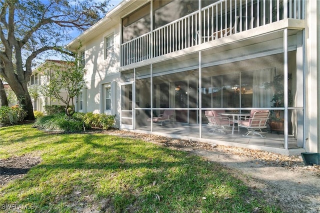 back of house with a patio, a yard, and a balcony