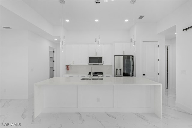 kitchen featuring sink, white cabinetry, hanging light fixtures, stainless steel appliances, and a spacious island