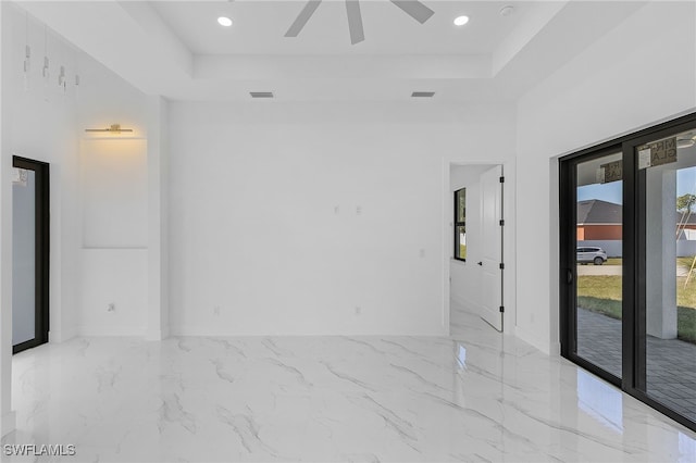 spare room featuring ceiling fan and a tray ceiling