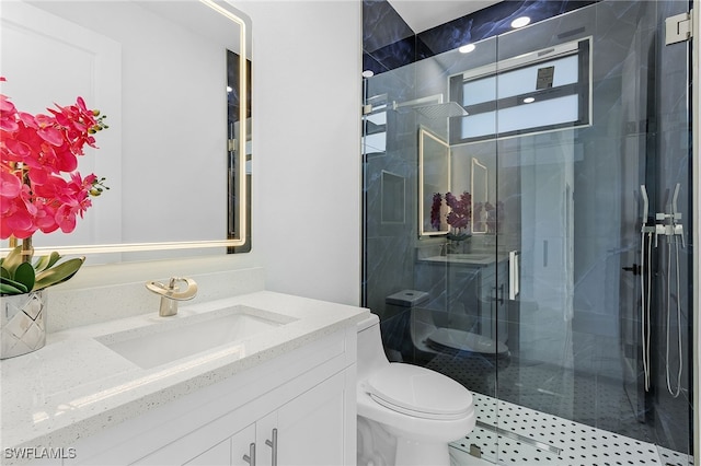 bathroom with vanity, a shower with door, and toilet