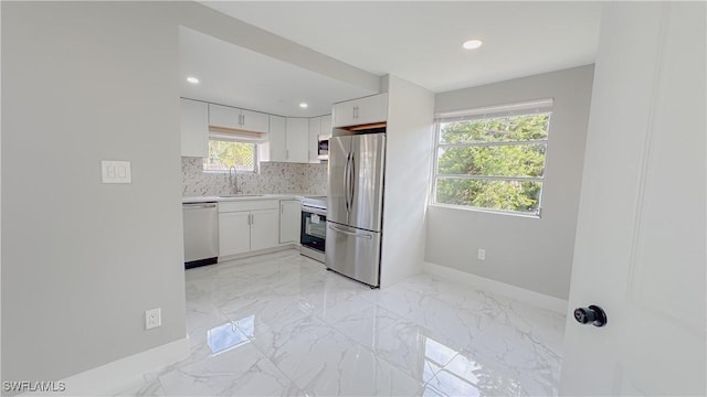 kitchen featuring white cabinetry, stainless steel appliances, sink, and backsplash