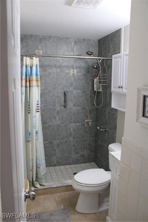 bathroom featuring tile patterned flooring, vanity, curtained shower, and toilet