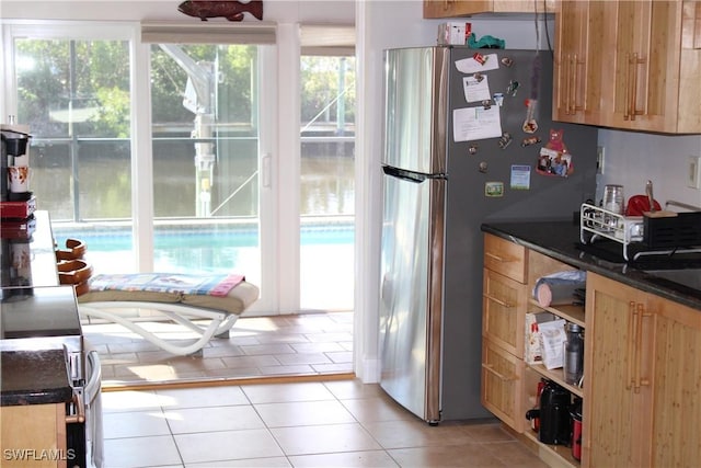 kitchen with light tile patterned floors and stainless steel refrigerator