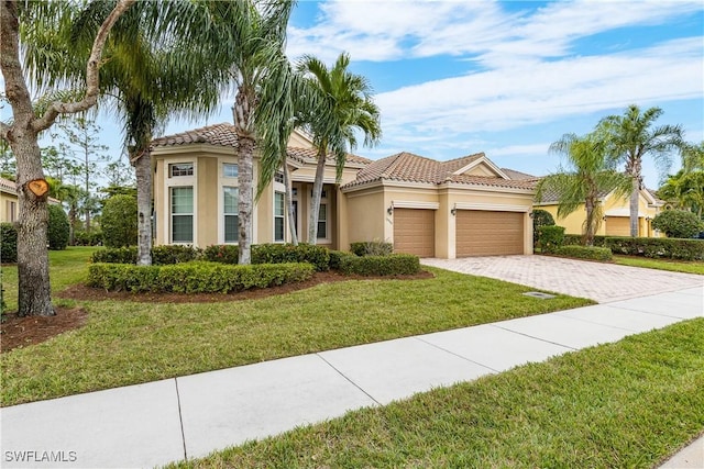 mediterranean / spanish-style home with a garage and a front yard