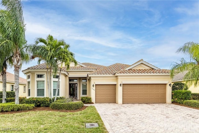 mediterranean / spanish-style house featuring a garage and a front yard