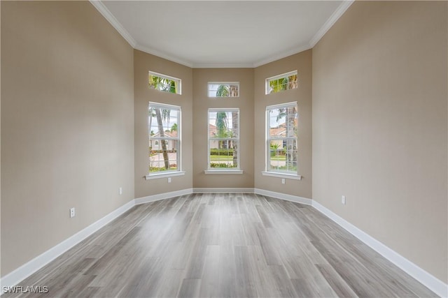 unfurnished room featuring ornamental molding and light wood-type flooring