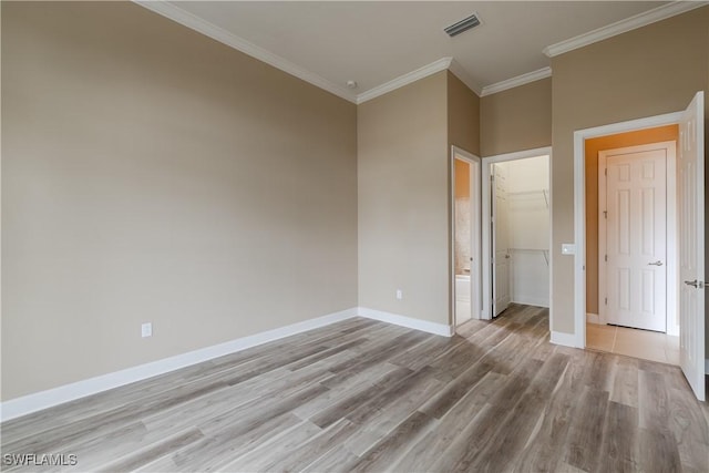 unfurnished bedroom with light hardwood / wood-style flooring, ornamental molding, and a closet