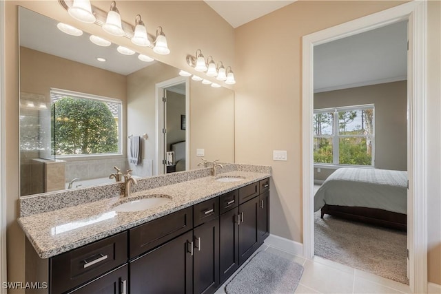 bathroom with tile patterned flooring, vanity, and a washtub