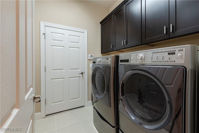 washroom featuring cabinets, washer and clothes dryer, and light tile patterned floors