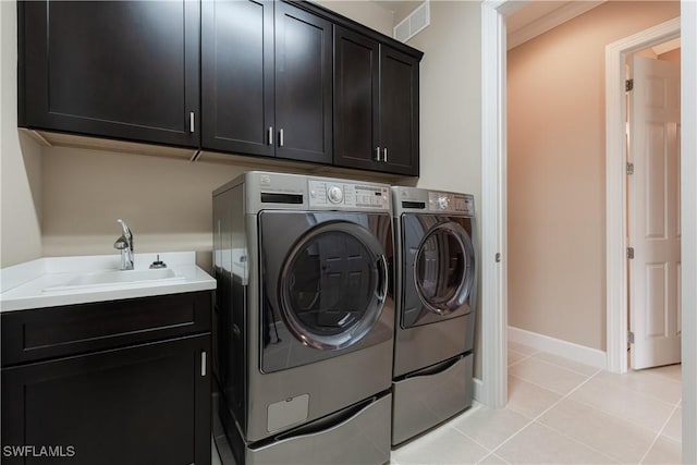 clothes washing area featuring cabinets, washing machine and dryer, sink, and light tile patterned floors