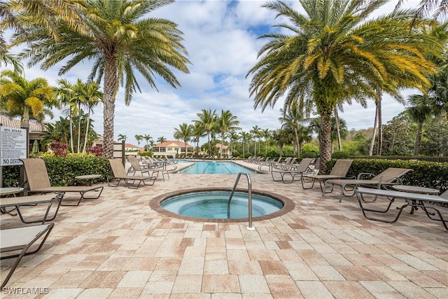 view of swimming pool with a hot tub and a patio