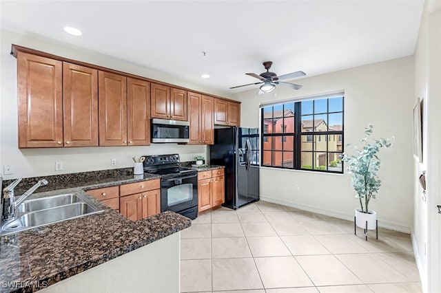 kitchen featuring light tile patterned flooring, sink, ceiling fan, dark stone counters, and black appliances