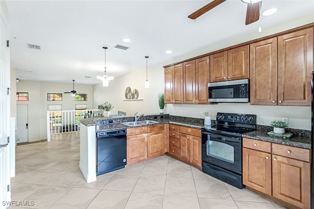 kitchen with decorative light fixtures, black appliances, sink, dark stone counters, and kitchen peninsula