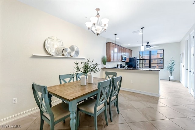 tiled dining area with ceiling fan with notable chandelier