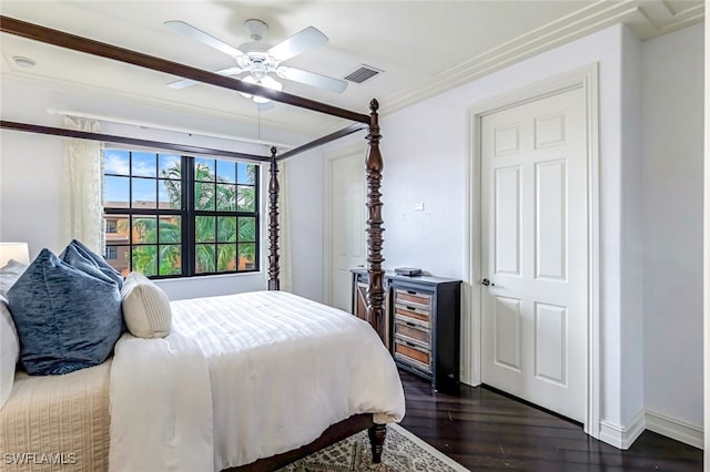 bedroom featuring visible vents, dark wood finished floors, baseboards, ceiling fan, and ornamental molding