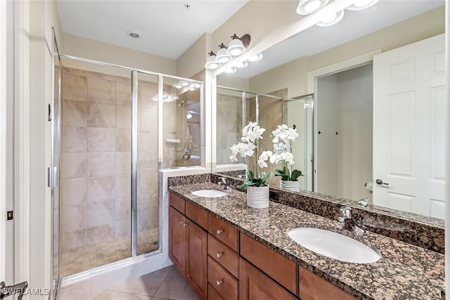 full bath featuring a sink, a shower stall, and double vanity