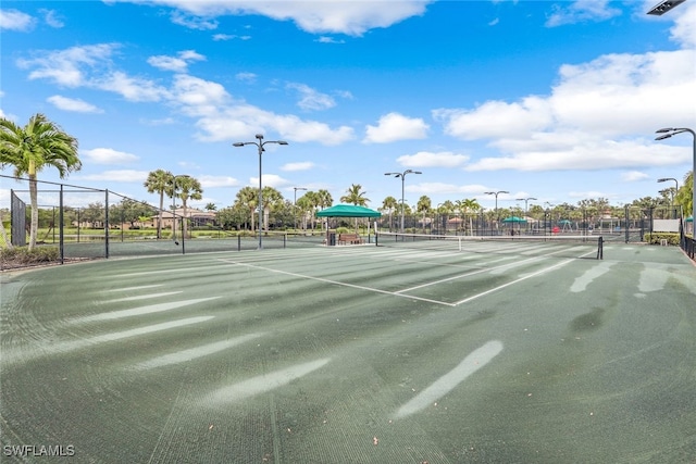 view of tennis court featuring fence